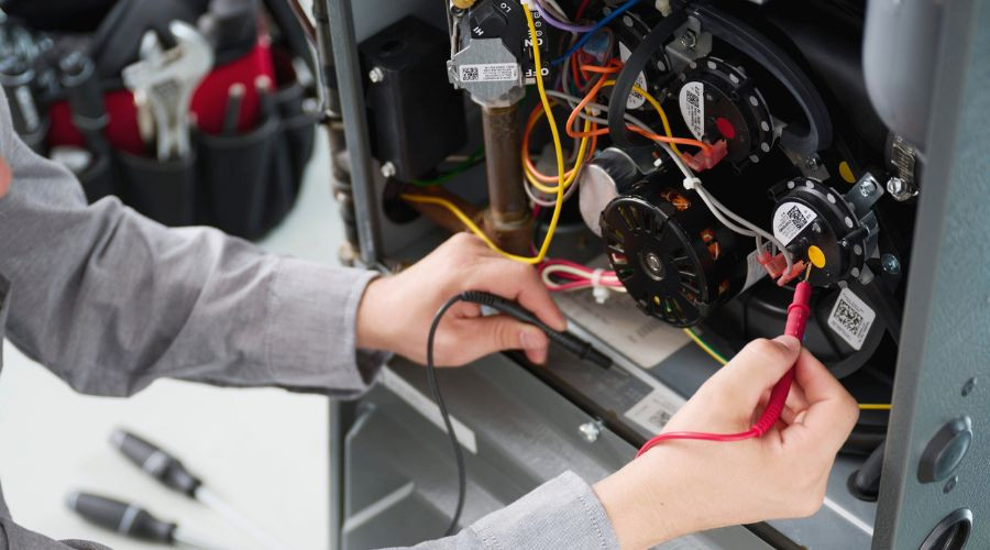 Technician using a multimeter on electrical components, highlighting precision for heater maintenance by City Plumbing.