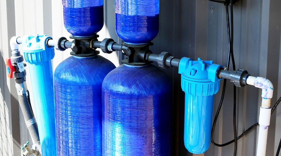Water filtration system with blue tanks and connected piping, illustrating home water purification solutions for clean drinking water.
